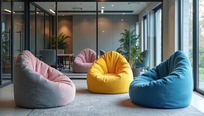 Stylish modern office lounge area. Colorful beanbag chairs offer comfortable relaxation in open workspace. Interior features contemporary design furniture with glass walls and plants.