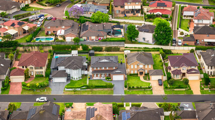 Aerial Shot of Houses and Streets in a Green Suburban Environment