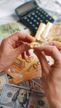 Hands toss and rotate BTC bitcoin against the dollars and euros