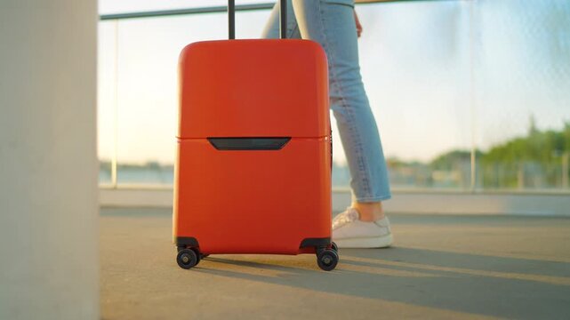 Woman confidently pulling a suitcase in an airport terminal. Slow motion