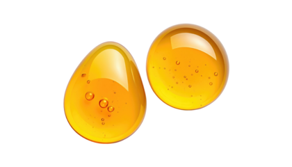Two glistening golden drops with bubbles, against a pure black background, reflecting light and suggesting liquid viscosity