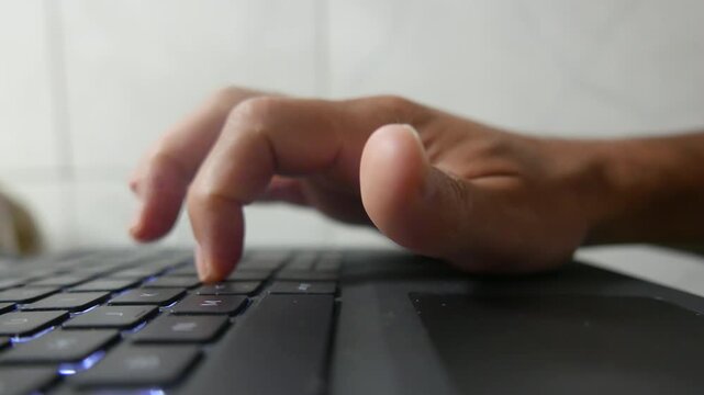 A shaky and immersive POV of someone typing on a laptop. A person typing on a computer keyboard. A close-up of a laptop keyboard. Computer keys.