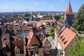 Panoramic view of Nuremberg's old town from Kaiserburg Nuremberg, featuring Bavarian timber-framed houses, medieval towers, and red rooftops under a clear summer sky.