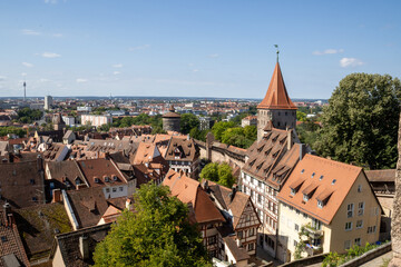 Panoramic view of Nuremberg's old town from Kaiserburg Nuremberg, featuring Bavarian timber-framed houses, medieval towers, and red rooftops under a clear summer sky.