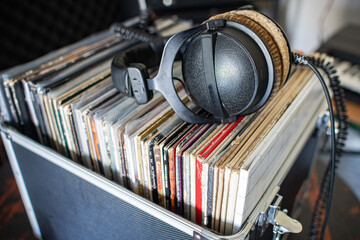 Collection of vintage vinyl albums with professional DJ headphones on top.