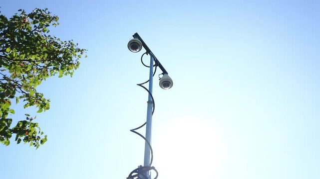 Mobile police surveillance tower with the multiple security cameras raised on a telescoping mast in a suburban neighborhood with blue sky. public safety, monitoring