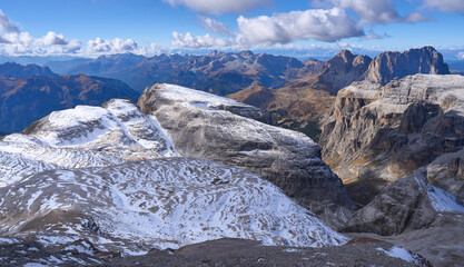 West view from the summit of Piz Boe peak, the highest mount in the Sella Group of the Dolomites. Mountain landscape - panorama in the autumn sunny day. Mountains covered by snow. 