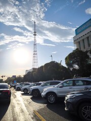 Fototapeta premium The Koktobe TV tower against the backdrop of a city street with parked cars in Almaty.