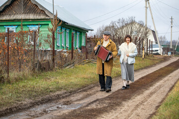 A retired couple are walking through the village.