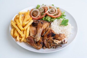 Grilled chicken rice fries salad, roasted chicken pieces with jasmine rice, golden fries and fresh tomato and onion rings, parsley garnish, casual bistro lunch