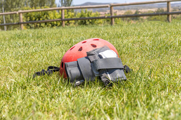 A red helmet and A gray wrist guard on the green grass background