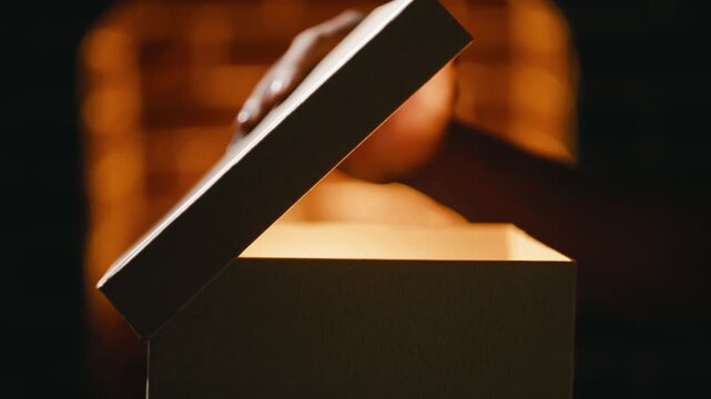 Hand opens mysterious package containing Christmas gifts