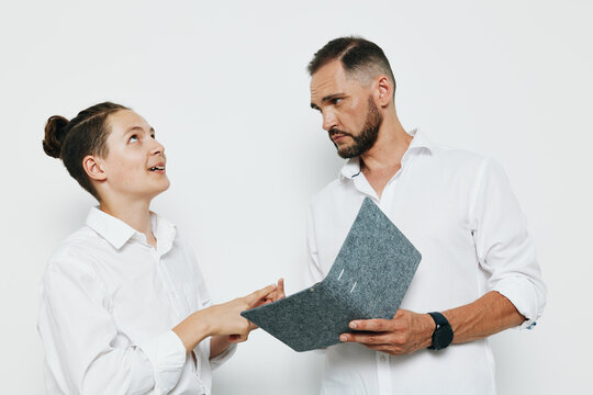 A professional business man with focused expression reviews documents against a vibrant, isolated colorful background, conveying confidence, calm leadership, and strategic poise.