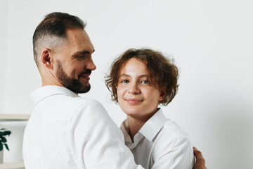 Business professional man with calm smile embraces a colleague on an isolated colored background, conveying confidence, cooperation, and shared success in a corporate setting.