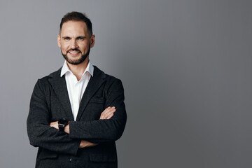 A confident business professional man stands with arms crossed against an isolated colored background, conveying calm focus, readiness, and friendly assurance.