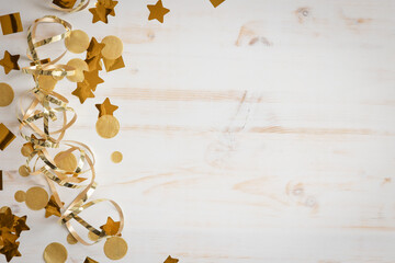 border of gold streamers and confetti on a white background