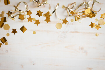 Border of gold streamers and confetti on white