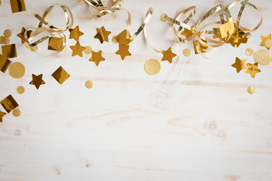 Border of gold streamers and confetti on white
