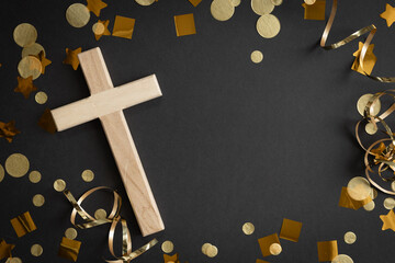 Cross with gold streamers and confetti on black