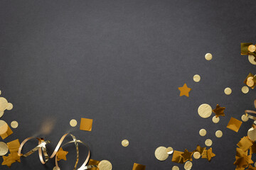 Border of gold streamers and confetti on a black background