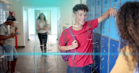 Leaning teenage boy in red t-shirt carrying purple backpack chatting and smiling by school lockers