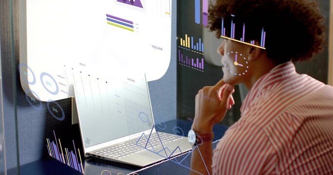 Leaning data analyst in striped shirt analyzing AR overlays at office desk, with laptop, copy space