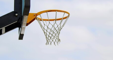 Showing basketball hoop with orange rim and white net at outdoor court left, copy space