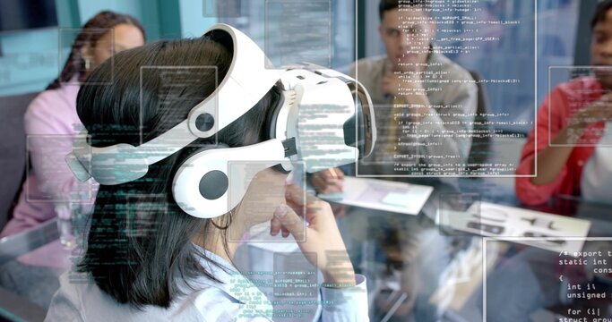 Wearing white headset, woman in blue shirt watching code at conference table, with laptop