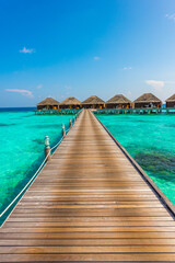 Wooden deck goes to bungalows. Tropical island beach landscape exotic shore coast. Tranquil closeup calm sea water waves. Summer vacation, holiday amazing nature. Relax paradise, Maldives.