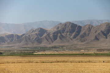 Obraz premium Markau Mountain near Ashgabat with arid valley, dry hills and sparse trees under clear blue sky. g.