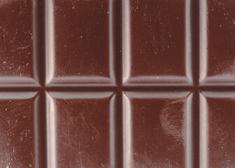 A detailed macro photograph of a glossy chocolate bar
