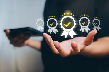 Quality assurance concept. Business person holding digital award badges with check marks, representing certification, standard excellence, and professional performance recognition.