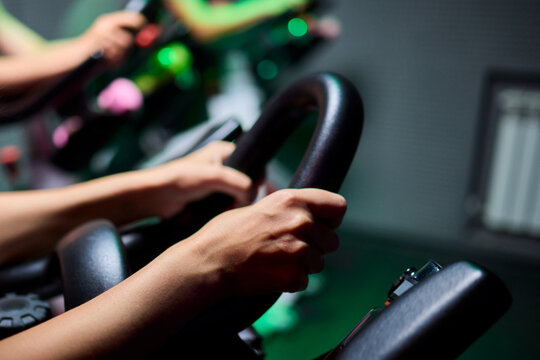 Woman cycling on pink exercise bike with magenta bicycle handlebar in gym - Powered by Adobe