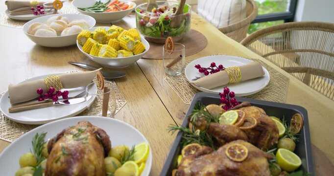Camera starting close-up on roasted chickens and potatoes, panning holiday table showcasing feast