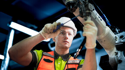 An engineer works on an AI robotic arm, representing the future of work. This advanced...