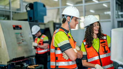 A team of engineers operates an industrial robot or CNC machine. They are in a smart factory, manufacturing advanced AI microchips or high tech components.