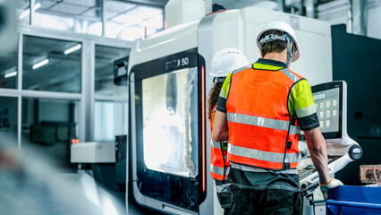 Engineers program an industrial robot or 5-axis CNC machine using an AI interface. The team manufactures advanced microchips or high-tech components in a smart factory.