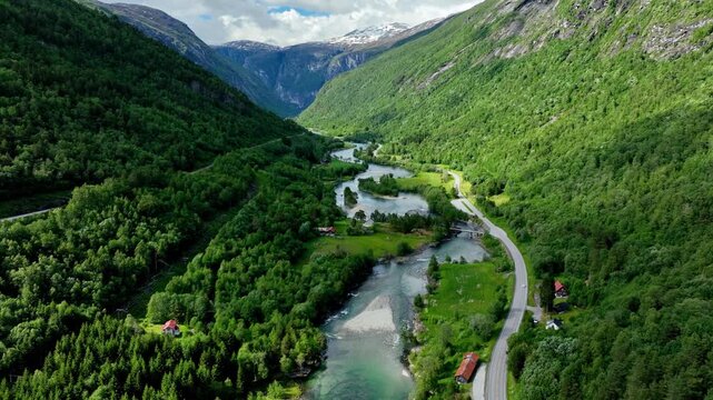 Aerial of the Rauma river winding through meadows and farmland in the Romsdalen Valley in Norway.