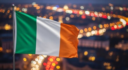 Flag of Ireland waving against a blurred background bokeh lights of a city at night. Concept for national pride and independence Day.