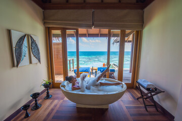 Woman posing inside bath tube. Tropical island beach landscape exotic shore coast.  Summer vacation, holiday amazing nature. Relax paradise, Maldives.