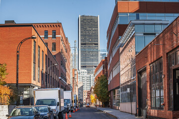 Downtown Montreal street view leading toward corporate towers and the skyline. Brick buildings,...