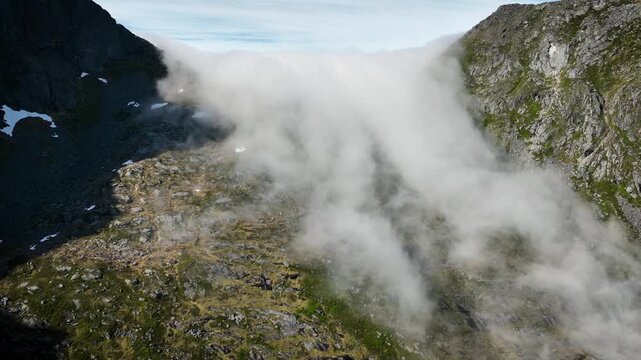 Aerial of of the clouds flowing over a mountain in Norway