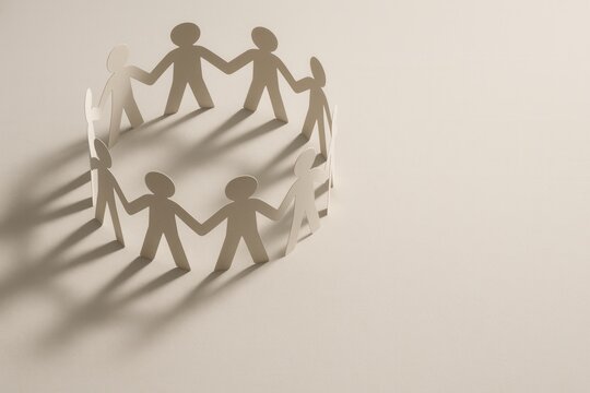 Paper cutout figures forming a circle for unity and collaborative teamwork