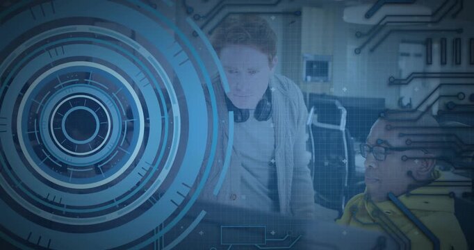 Standing colleague leaning in, seated dev debugging code while blue HUD overlaying screen shifting