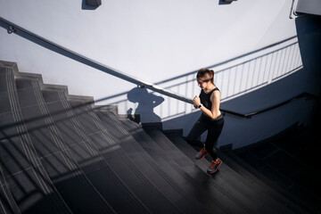 Young woman running up urban stairs for fitness workout