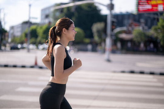 Woman running through city street at daytime