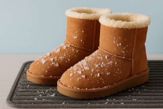 Warm brown winter boots with faux fur lining and snowflakes on mat, cozy seasonal footwear for cold weather comfort