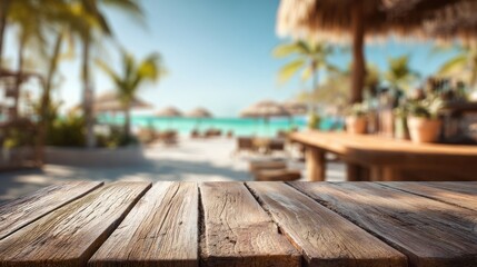 A close-up of a wooden table contrasts with a blurred beach scene, palm trees, and thatched umbrellas. Clear sky and turquoise water