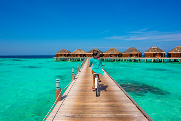 Woman riding bicycle. Tropical island beach landscape exotic shore coast. Tranquil closeup calm sea water waves with palm trees. Holiday amazing nature. Relax paradise, Maldives.