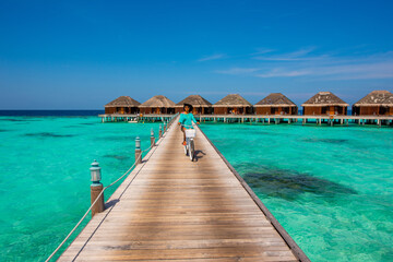 Woman riding bicycle. Tropical island beach landscape exotic shore coast. Tranquil closeup calm sea water waves with palm trees. Holiday amazing nature. Relax paradise, Maldives.